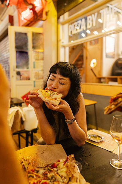 istock An Asian woman eating pizza 2250082316