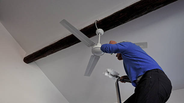 istock Man cleans debris off of ceiling fan 2250087006