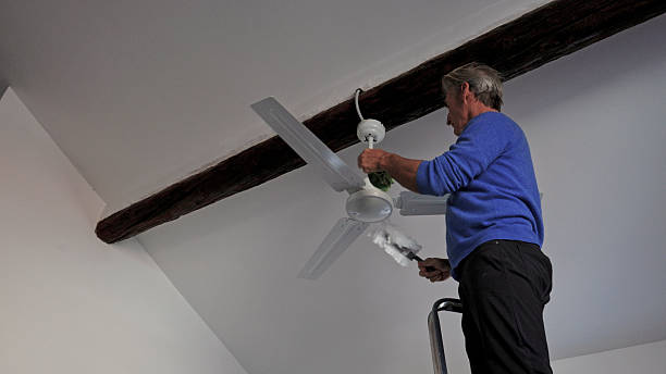 istock Man cleans debris off of ceiling fan 2250087007