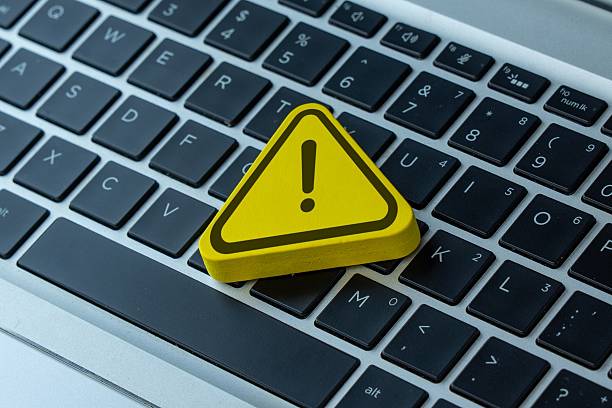 istock A yellow warning sign with an exclamation mark placed on a laptop. 2250087606