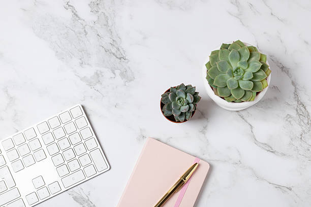 istock Horizontal flat lay of white keyboard, pink notebook and succulents on a marble background, bright minimalist composition with copy space. Concept of modern workspace and creative lifestyle 2250088784