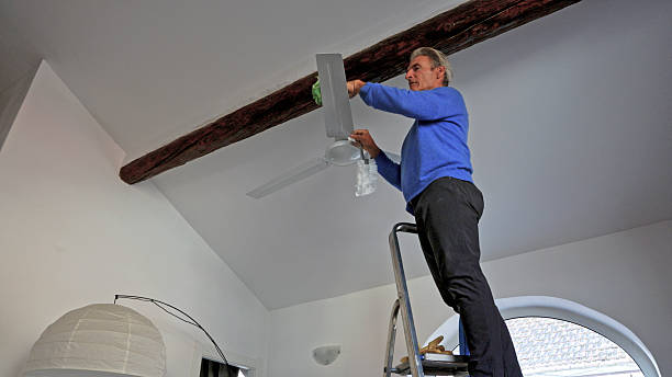 istock Man cleans debris off of ceiling fan 2250088787