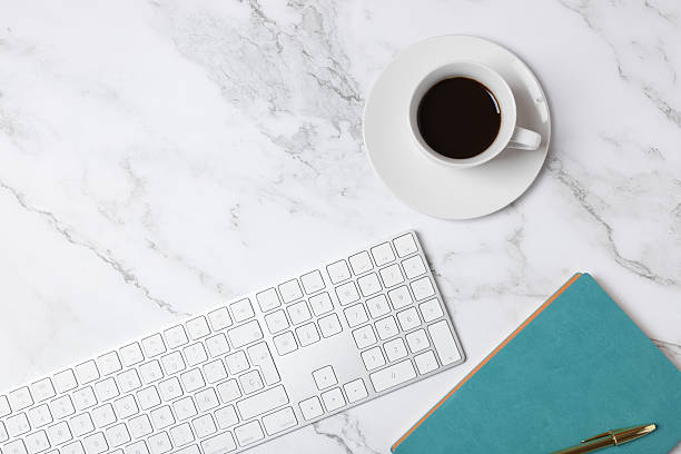 istock Top view horizontal of coffee cup, white keyboard and turquoise notebook on marble background with copy space, clean minimalist workspace style. Concept of modern workspace and creative lifestyle 2250088808