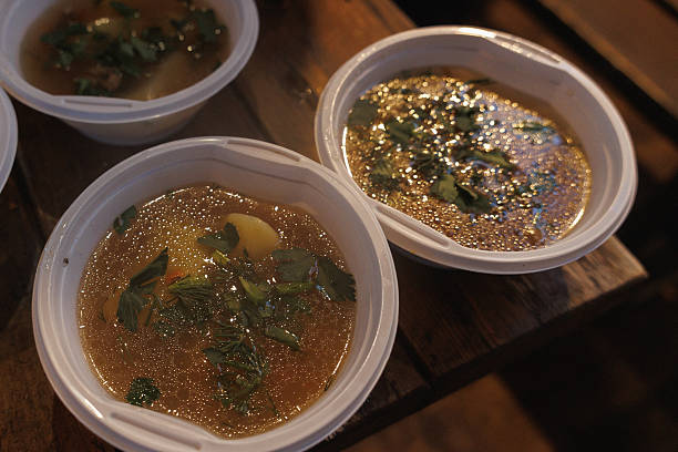 Bowls Of Soup With Herbs, Steaming Ceramic Bowls On Wooden Table, Clear Golden Broth Dotted With Chopped