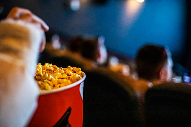 istock Eating popcorn while watching a movie at the cinema 2250095529
