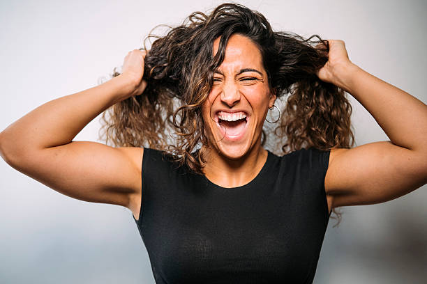 istock Woman screaming in frustration pulling her curly hair 2250098542