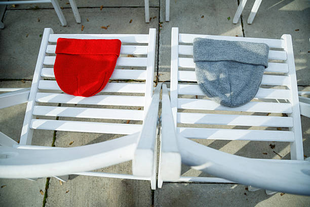 Two hats of red and gray on white chairs