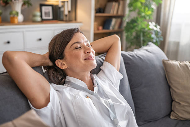 istock Healthcare worker relaxing on sofa at home after shift 2250101604