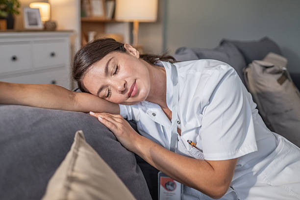 istock Tired female nurse sleeping on couch at home 2250101834