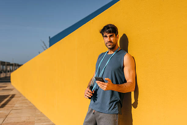 istock Portrait of a young man leaning on a wall using a smartphone 2250104045