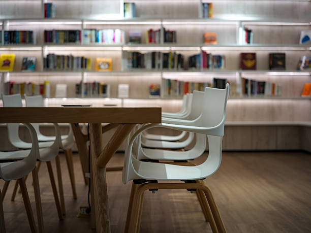 Blurred background of public library, bookshelf with books, education concept