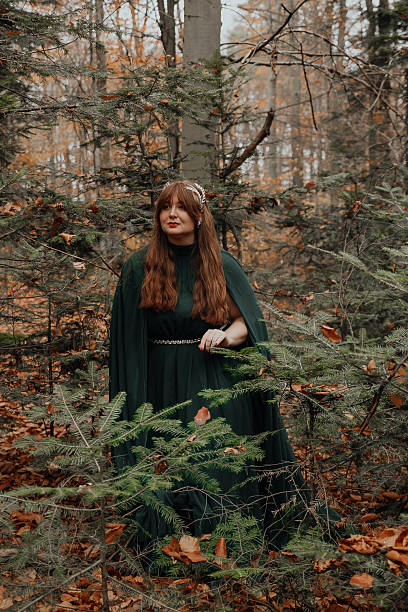 istock Woman in Green Cloak Standing Among Trees 2250108471