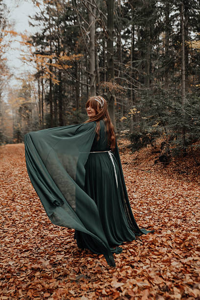 istock Woman Spreading Cloak in Autumn Forest 2250108969