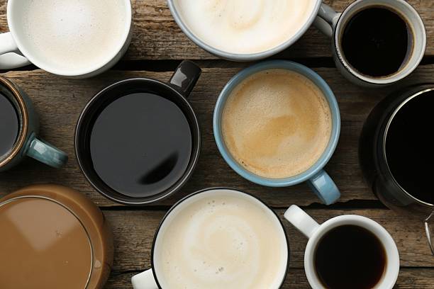 istock Different coffee drinks in cups on wooden table, flat lay 2250110477