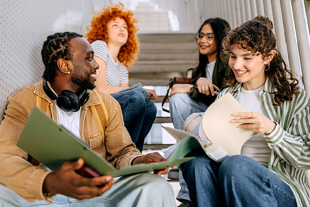 istock Group of university students sitting together on the stairs 2250111099