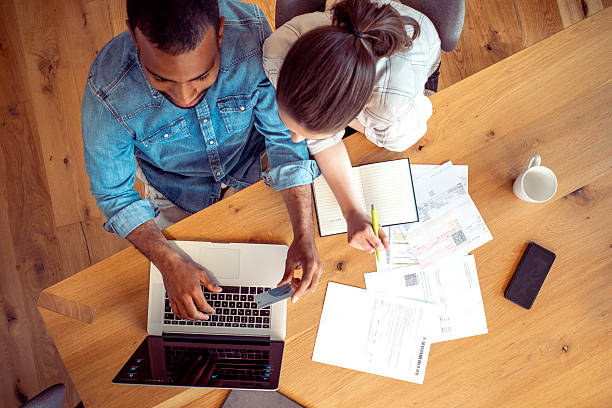 istock Focused Couple Analyzing Finances Together at Wooden Table 2250112401