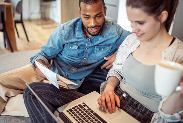 istock Mid Adult Couple Discussing Bills Over Coffee on Sofa 2250112430