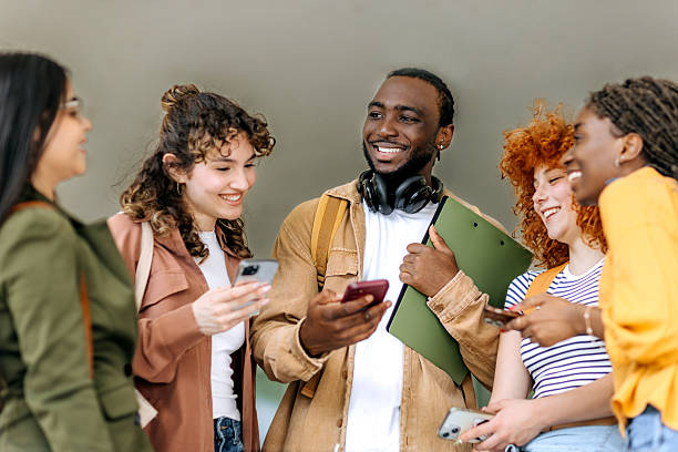 istock Group of university students standing outdoors using smartphones 2250118141
