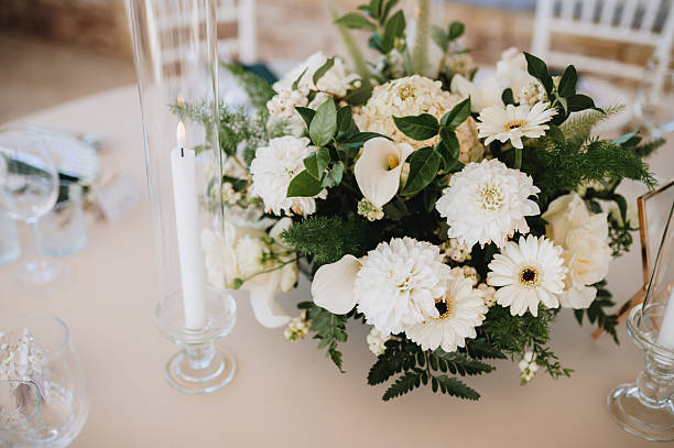 candles and white roses arranged in a wedding table