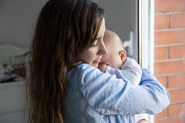 istock A mother tenderly hugs her baby while soothing them 2250122599