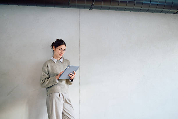 istock Woman working on tablet against concrete wall 2250122656