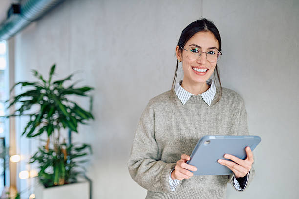 istock Smiling businesswoman holding tablet looking at camera 2250122722