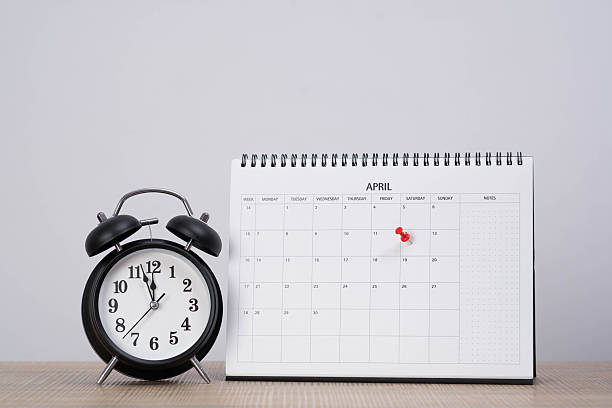 istock Alarm clock beside a desk calendar with a marked date in April, symbolizing scheduling, time management, reminders, deadlines, planning, and organizing important events in daily work or personal life. 2250127095