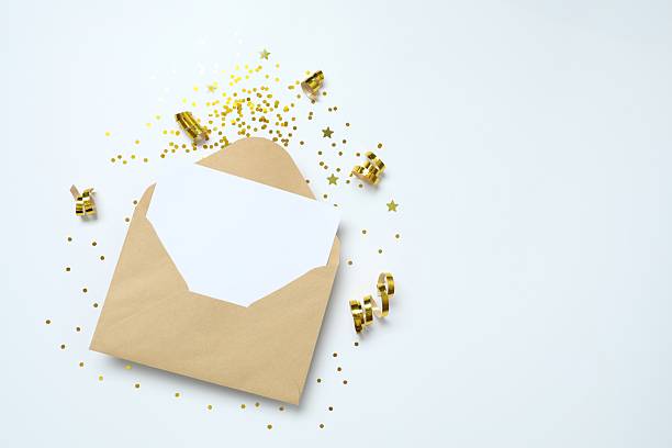 istock Paper envelope and golden confetti on white background, top view 2250127986