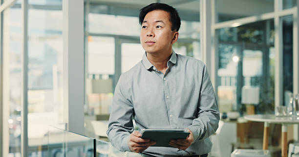 istock Business, tablet and thinking with Asian man in office for planning, problem solving or research. App, schedule and vision with corporate employee in workplace for company agenda or management 2250132260