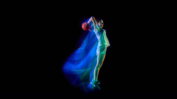 istock Basketball player jumping with ball in blue glowing motion blur. 2250135830