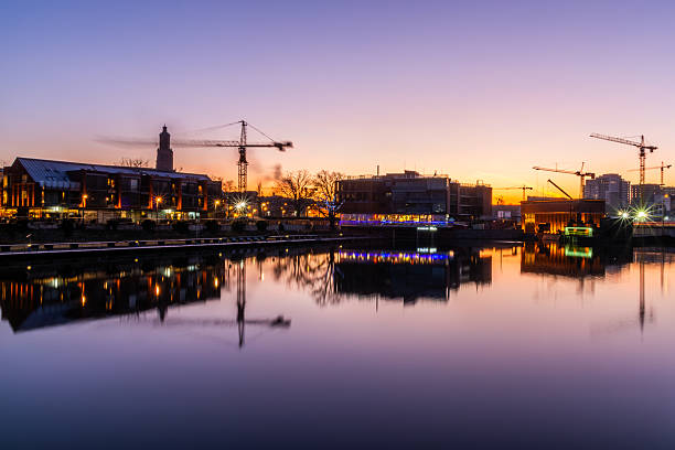 istock Construction Cranes Over City River At Sunset, Urban Skyline Lights And Reflection In Water Industrial Development Scene 2250137336