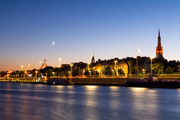 istock Evening City Landscape With Moon And Lights Reflecting In The River 2250138320