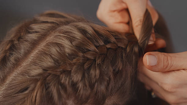 istock Skillful hands effortlessly braiding a young woman's blond hair 2250139265