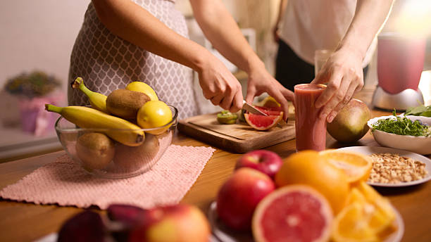 istock Couple preparing fruit for smoothies with fresh produce arranged on kitchen table 2250139955