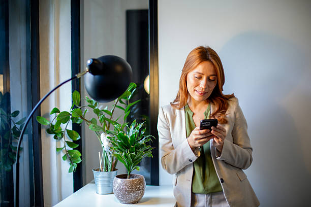 istock Businesswoman texting on smartphone sitting in modern office 2250142636