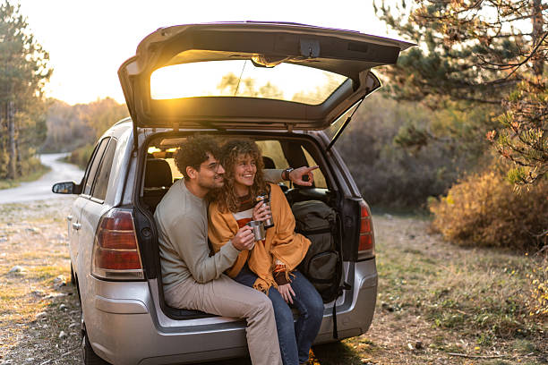 istock Couple enjoying road trip at sunset pointing view 2250142912