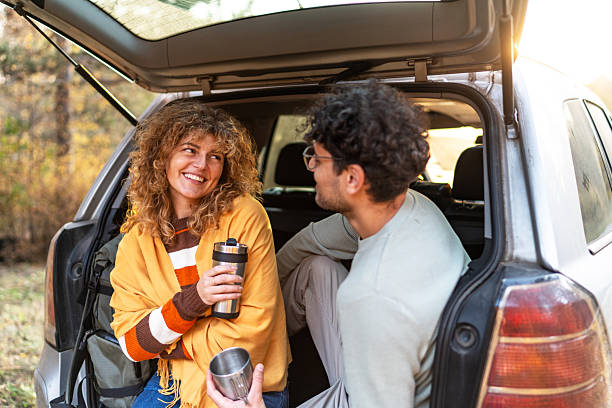 istock Couple relaxing in car trunk drinking coffee 2250142975
