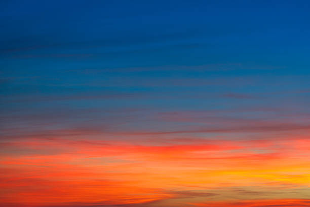 Vibrant background texture of an autumn sunset sky, captured from Tuscany in November 2025. The colors transition from blue at the top to fiery red, orange, and gold near horizon