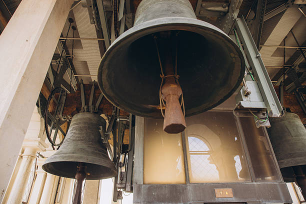 Venice, Italy - October 9, 2025: Interior shot of historic bronze bells hanging in a belfry, showcasing old mechanisms within a beautiful bell tower