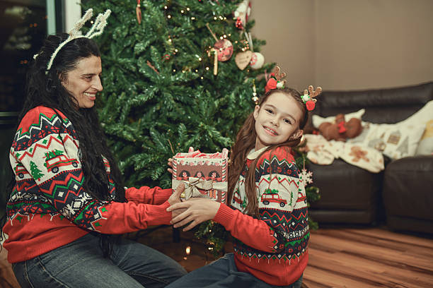 istock Exited Daughter Gets Christmas Gift While Celebrating with Her Mother 2250148793