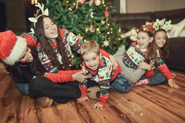 istock Family Celebrating Christmas With Matching Sweaters And Tree Decorating At Home 2250149113