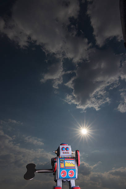 Vintage toy robot with sky behind. Artificial intelligence concept. Dark ambient.