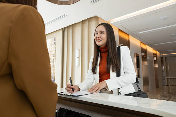 istock Businesswoman checking in at office reception desk 2250159232