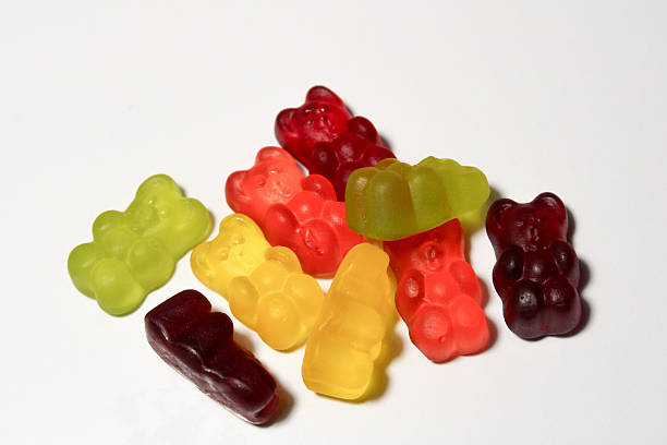 istock Mixed gummy bears in various bright colors arranged randomly on white surface displaying chewy candy texture and bear shape 2250160493