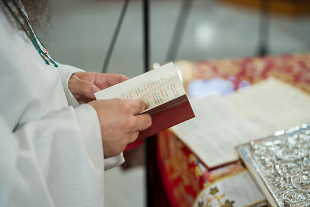 istock Person holds a prayer book while standing in a religious setting during a ceremony in a church 2250162115