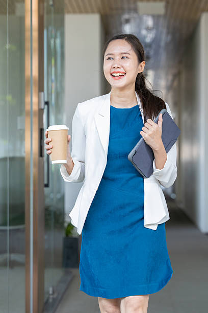 istock Confident businesswoman walking with coffee and tablet 2250163474