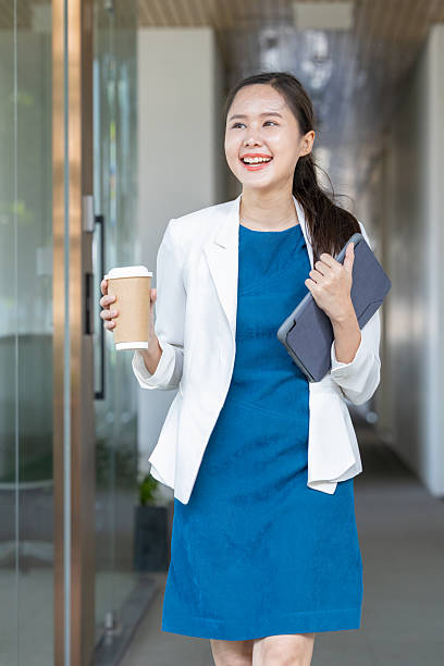 istock Confident businesswoman walking with coffee and tablet 2250163787