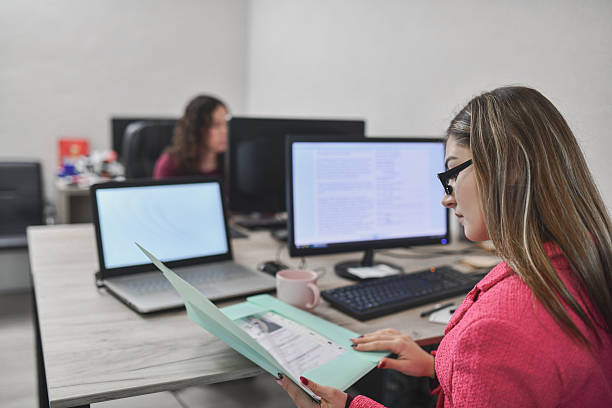 istock Two Employees Focused on Paperwork and Interaction, Reviewing Candidate Information and Exchanging Insights During an Interview in a Modern Office 2250165195