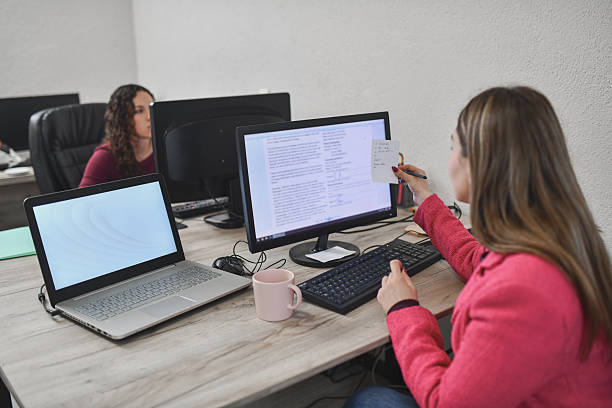 istock Two Coworkers Working in an Office On Computers, Reviewing Documents, And Conducting an Interview 2250165253