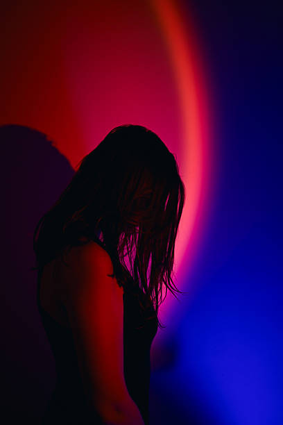 istock Woman silhouette reflecting on vibrant red and blue light 2250167275